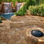 Beautifully landscaped pool area with natural stone features and vibrant greenery.