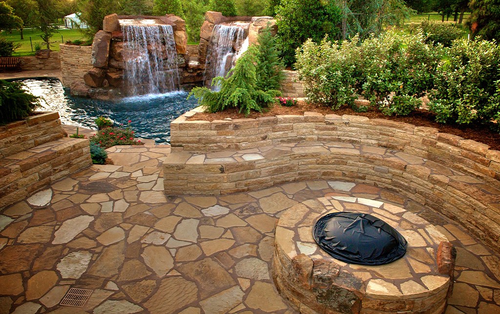 Beautifully landscaped pool area with natural stone features and vibrant greenery.